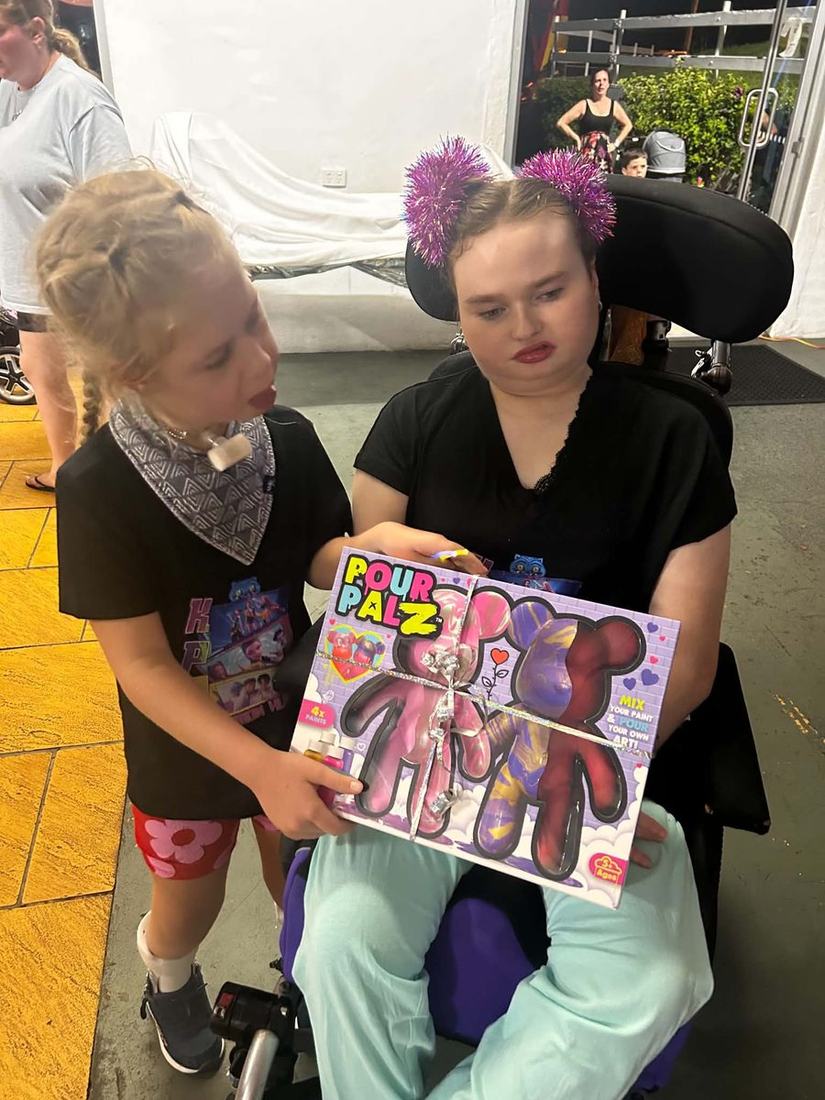 Florence and Shontae sitting side by side, holding up a craft kit they are about to start