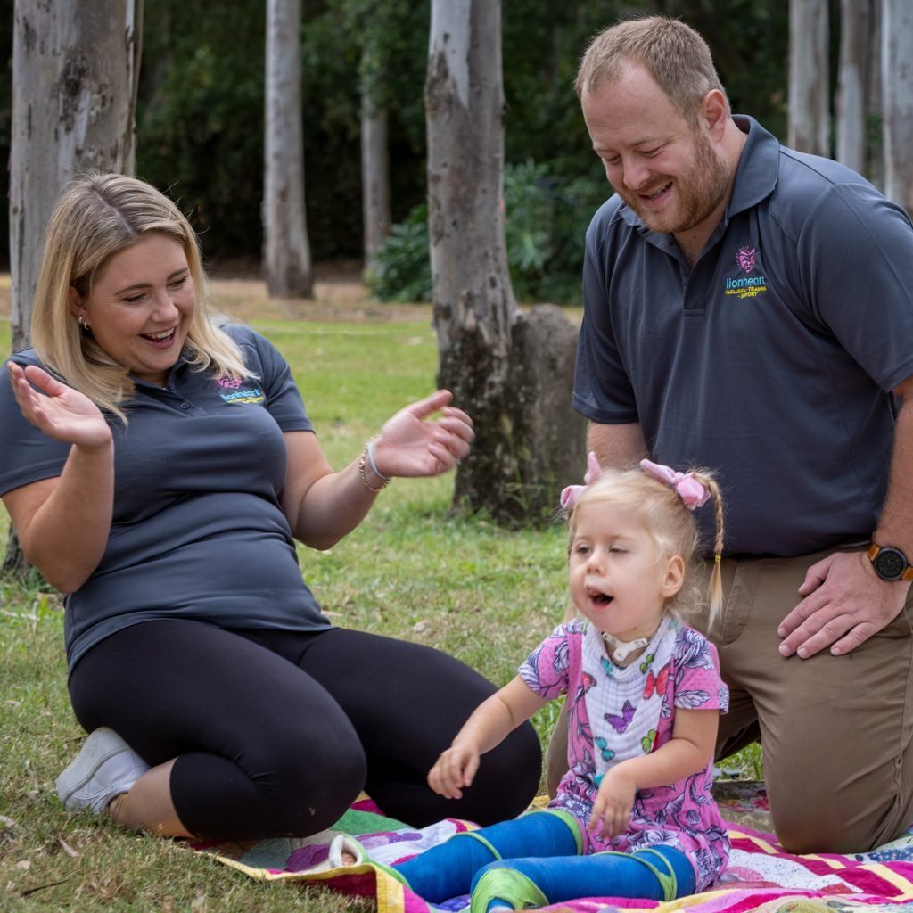 Brett and Ellie outdoors on a picnic rug with their daughter Florence