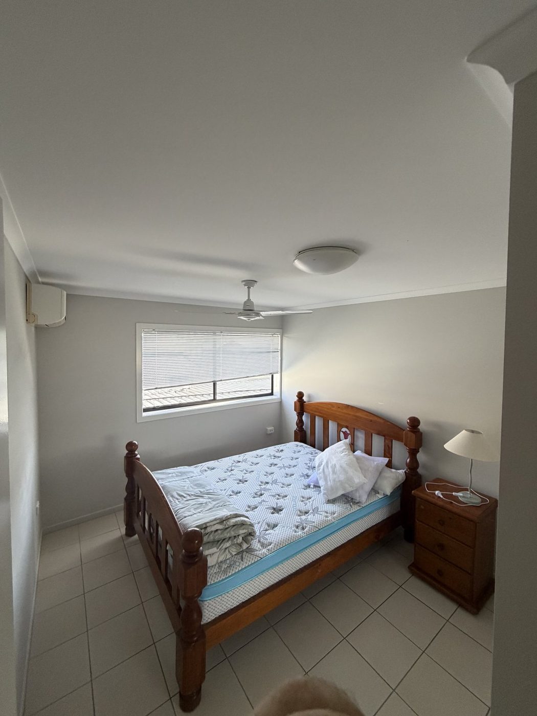 A bedroom in the emergency apartment, with a double bed, bedside table and window