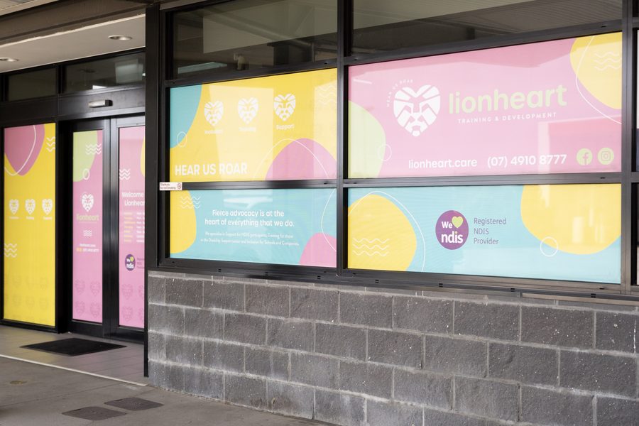 The Boowan Court shopfront: glass doors and windows in Lionheart pink, teal and yellow, with the lionheart logo and phone number